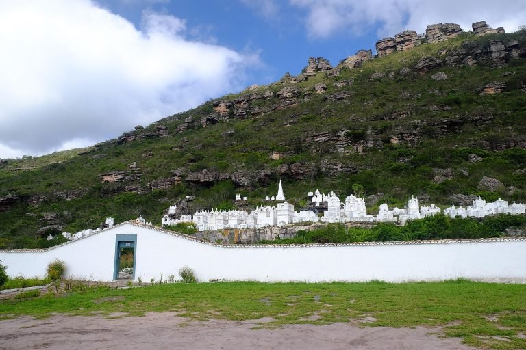 Conjunto de túmulos brancos ao pé da serra, atrás de um muro branco