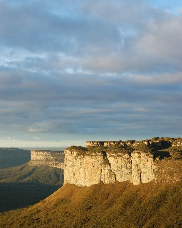 Paredão de morro de topo plano iluminado pela luz dourada do fim da tarde